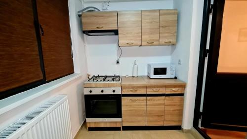 a small kitchen with a stove and a microwave at Cozy Studio in Brăila