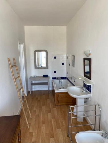 une salle de bain avec deux lavabos et une baignoire dans l'établissement La Maison du Port, à Mortagne-sur-Gironde