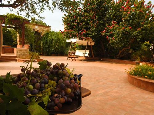 a bunch of grapes in a bowl on a patio at Mouzaliko Guesthouse Mansion in Kambos