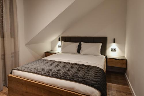 - une chambre avec un grand lit et 2 tables de chevet dans l'établissement Apartmani Studio Proforma, à Kolašin