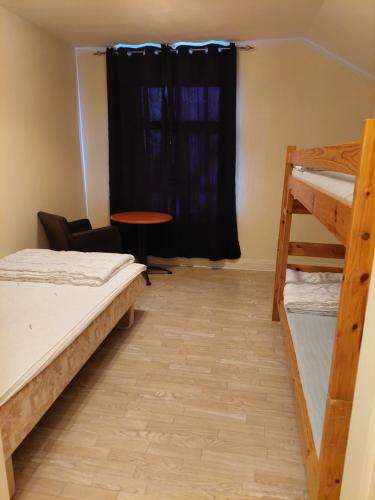 a room with two bunk beds and a table at Birkagårdens Vandrarhem in Åled