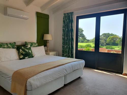 a bedroom with a large bed and a large window at Villa at Selborne Golf Estate in Pennington