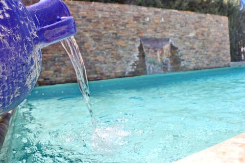 una persona está vertiendo agua en una piscina en Chalet La Roa III, en Conil de la Frontera