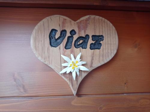 un corazón de madera con una flor en la pared en Telemark Mountain Rooms, en Agordo