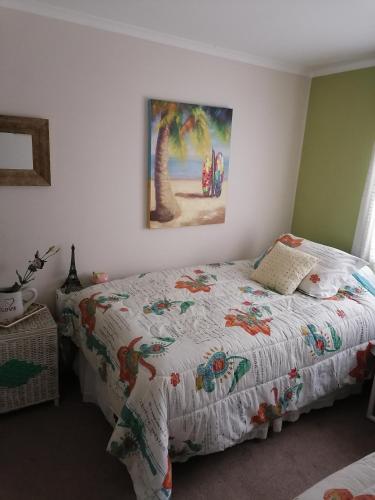 a bedroom with a bed and a painting on the wall at Depto Ambiente Privado con Vista al Mar in Concón