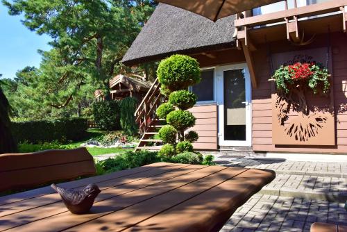 a patio with a wooden table in front of a house at Vila Deva in Neringa