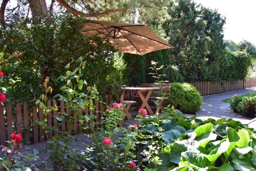 a garden with a wooden fence and an umbrella at Vila Deva in Neringa