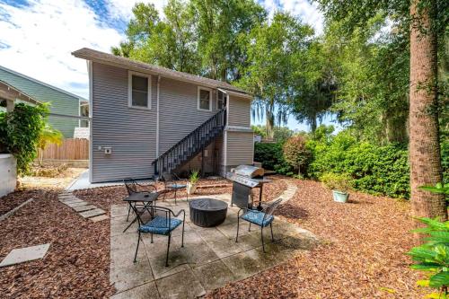 a backyard with chairs and a grill and a house at Historic Tremain Cottages in Mount Dora