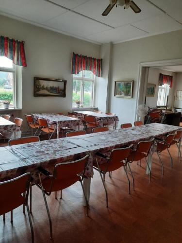 a large room with tables and chairs in it at Birkagårdens Vandrarhem in Åled