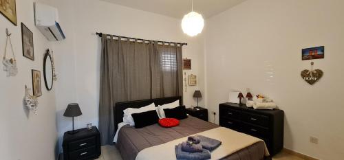 ein Schlafzimmer mit einem Bett und einer Kommode darin in der Unterkunft Charalambous Apartment in Paphos City