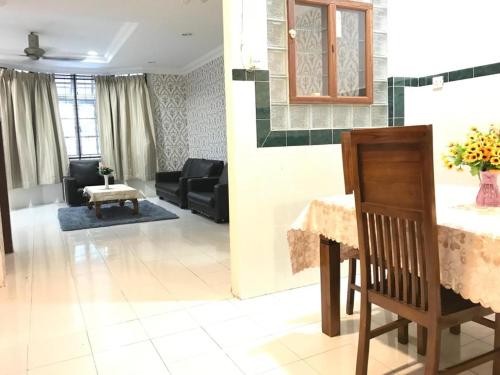 a living room with a table and a couch at Suria Permai Homestay in Taiping