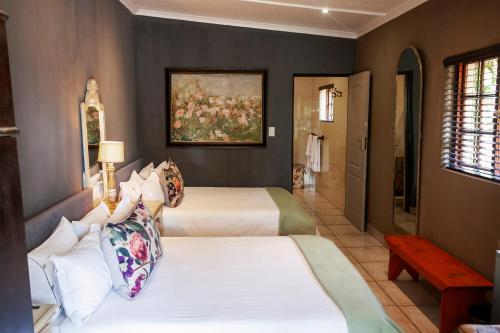 a bedroom with two beds and a painting on the wall at Town and Country Mpumalanga in Middelburg