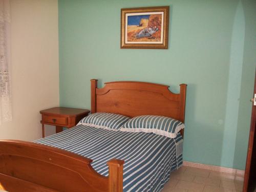 1 dormitorio con 1 cama y una foto en la pared en Chacara na Serra da Mantiqueira, en Santo Antônio do Pinhal