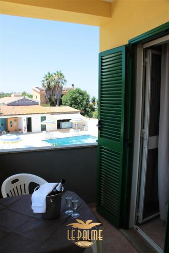 a balcony with a table and a view of a pool at Le Palme Holidays in Palmadula