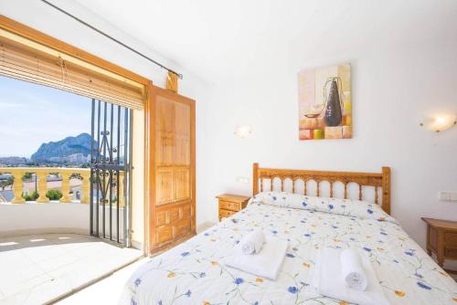 a bedroom with a bed and a large window at Villa Cactus - PlusHolidays in Calpe