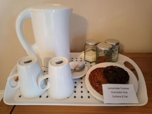 a tray with a tea pot and a plate of food at Corsewall Arms Guest House in Stranraer
