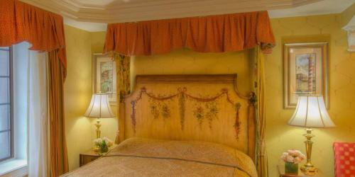 a bedroom with a canopy bed with orange curtains at Red Coach Inn in Niagara Falls