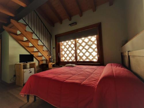 a bedroom with a large red bed with a window at Agriturismo Teresa delle Fragole in Viganò