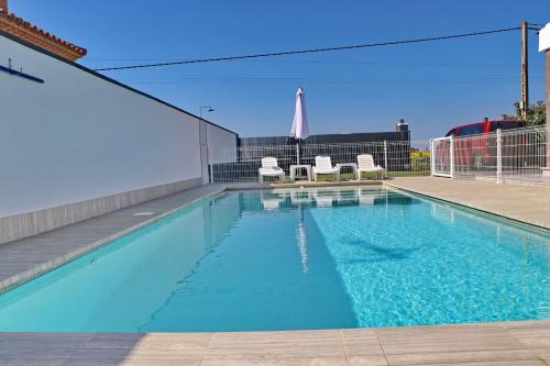 una piscina con agua azul en un edificio en Chalet moderno con pisicina, en Conil de la Frontera