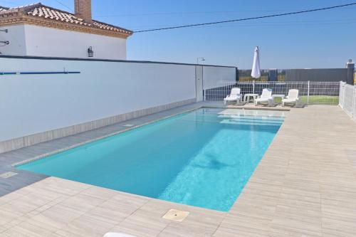 una gran piscina con 2 sillas en Chalet moderno con pisicina, en Conil de la Frontera