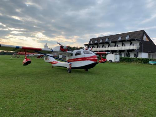 un pequeño avión estacionado en un campo al lado de un edificio en Boardinghouse Breitscheid en Breitscheid