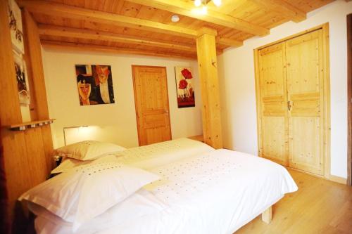 a white bed in a room with a wooden ceiling at Le Valombré in Saint-Pierre-de-Chartreuse