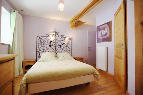 a bedroom with a bed with a metal headboard at Le Valombré in Saint-Pierre-de-Chartreuse