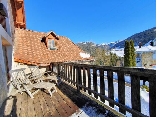 a deck with two chairs and a view of the mountains at Le Valombré in Saint-Pierre-de-Chartreuse