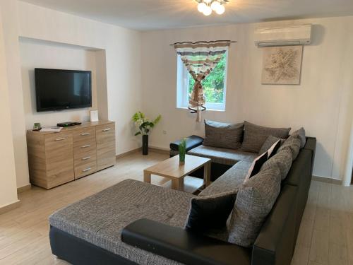 a living room with a couch and a tv at Villa KRK-4 bedrooms, 4 bathrooms with heated pool and jacuzzi, 150m from the sea in Krk