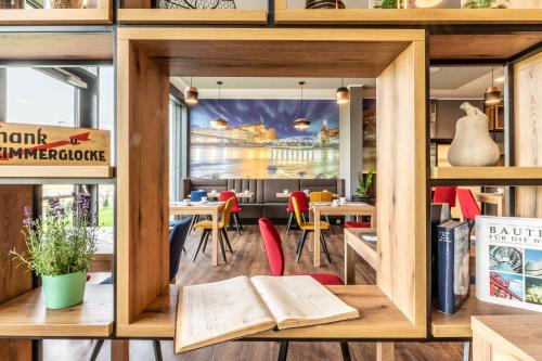 a room with tables and chairs and a book at Aiden by Best Western Stadtgut Hotel Steyr - FREE PARKING in Steyr