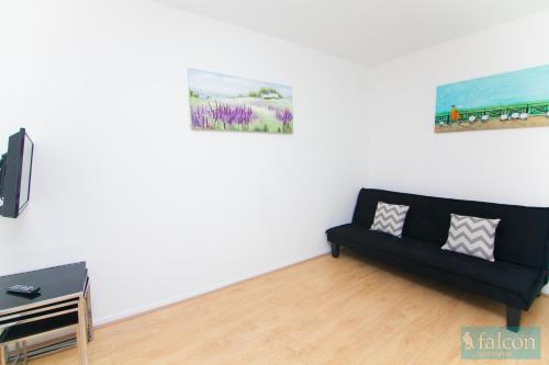 a living room with a couch and a painting on the wall at Maple Street Apartments in London