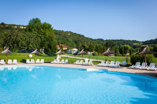 une grande piscine avec chaises et parasols dans l'établissement Domaine de l'Epinette, à Châtillon