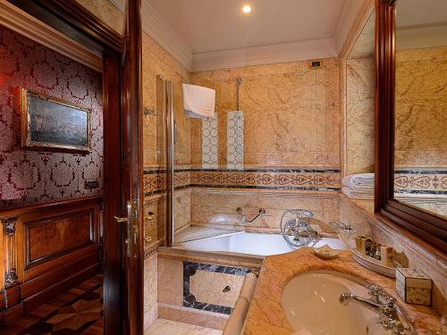 een badkamer met een bad en een wastafel bij Bellevue Luxury Rooms - San Marco Luxury in Venetië
