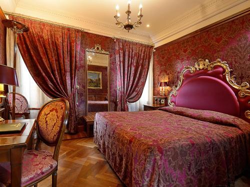 a bedroom with a bed and a table and chairs at Bellevue Luxury Rooms - San Marco Luxury in Venice