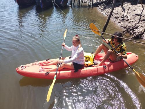 Dos chicas están sentadas en un kayak en el agua. en Activities Resort, en Ko Yao Yai