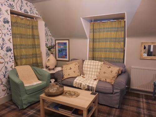 a living room with a couch and two chairs at Argyle Guest House in Tomintoul