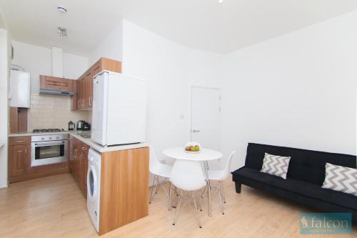 a kitchen and a living room with a couch and a table at Maple Street Apartments in London