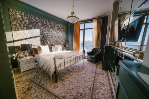 a bedroom with a bed and a large window at Ati Ambavi Botique Hotel Gudauri in Gudauri