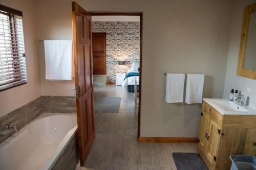 y baño con bañera y lavamanos. en Sol Montis Guest Cottage, en Paarl