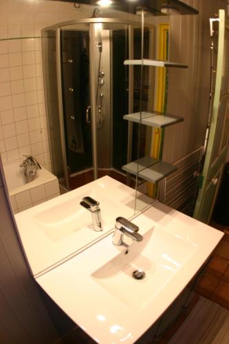 une salle de bain avec un lavabo blanc et un miroir dans l'établissement gite rural de La Neuville Roy, à La neuville roy