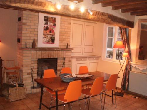 a dining room with a table and chairs and a fireplace at gite rural de La Neuville Roy in La neuville roy