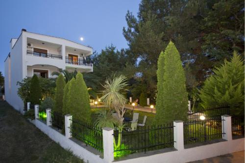 a white house with a fence and trees at Villa Katerina in Potos