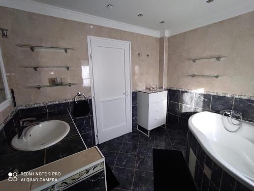 a bathroom with a tub and a sink and a tub and a toilet at Felhő Apartman in Balatonfüred