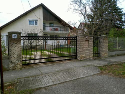 una valla de hierro forjado frente a una casa en Felhő Apartman, en Balatonfüred