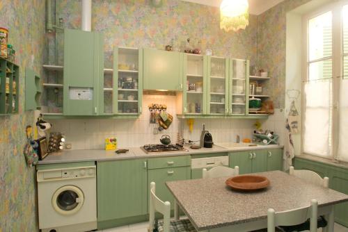 - une cuisine avec des placards verts et une table avec un évier dans l'établissement Cosimo, à Cannes