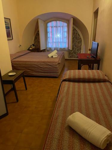 a hotel room with two beds and a window at Hotel Antica Dogana in Turin