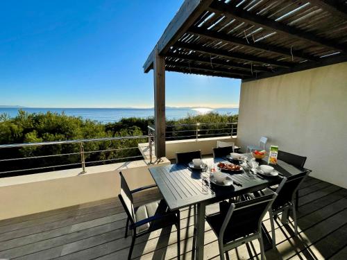 une table à manger sur un balcon avec vue sur l'océan dans l'établissement Appartement luxe Le Levant, à Hyères