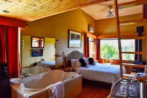 a bedroom with a tub and a bed and a bed and a bath tub at Auberge Hotel Spa Watel in Sainte-Agathe-des-Monts