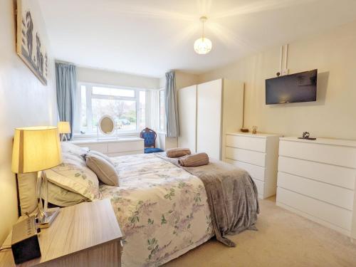 a bedroom with a bed and a desk and a tv at Ems Cottage - Emsworth in Emsworth
