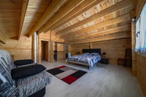 Habitación de madera con cama y sofá en Chalet L'Abitiz, en Puyvalador